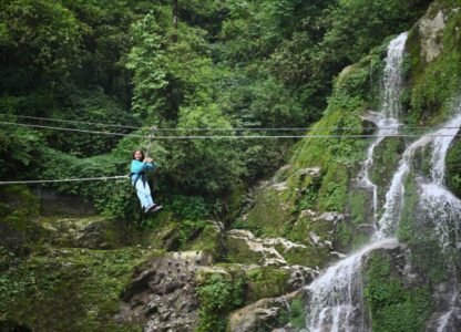 A girl zip-lining near a waterfall in Gangtok, Sikkim